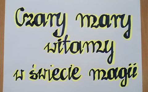 Biała kartka z czarno-zółtym napisem: Czary mary - witamy w świecie magii.