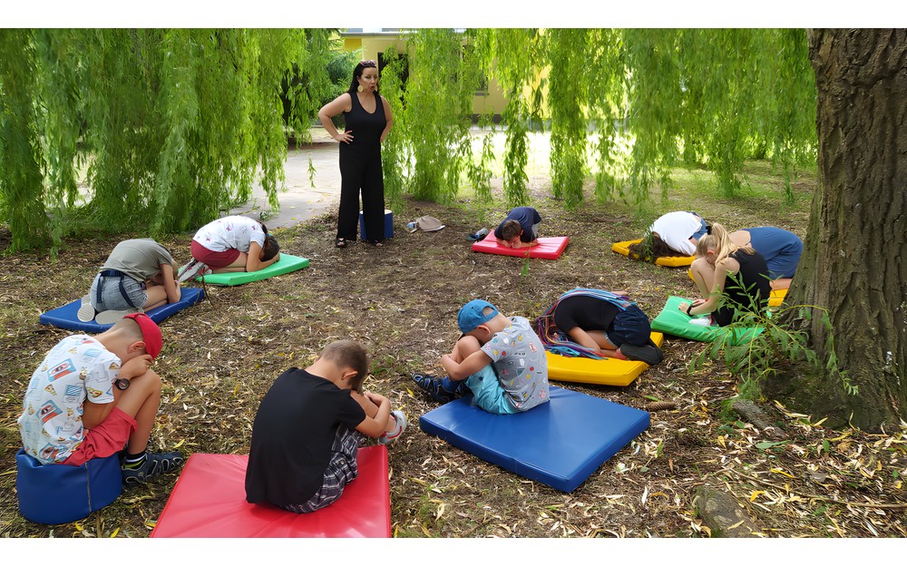 Dzieci  z animatorką w ogrodzie