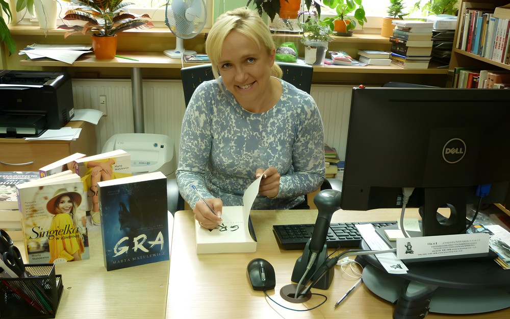 Marta Matulewicz pisze dedykację w swojej książce pt. GRA