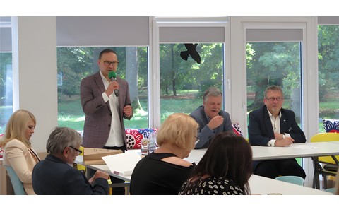 Dyrektor KBP Dariusz Pawlikowski otwiera konferencję, przemawiając do mikrofonu. Po jego prawej stronie siedzą: Dyrektor Książnicy Pomorskiej - Lucjan Bąbolewski oraz Zastępca Prezydenta Miasta Koszalina - Przemysław Krzyżanowski.