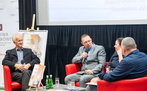 Prelegenci siedzą na scenie, od lewej: Krzysztof Urbanowicz, Kacper Pencarski, Dorota Cywińska oraz prowadzący Piotr Pawłowski.