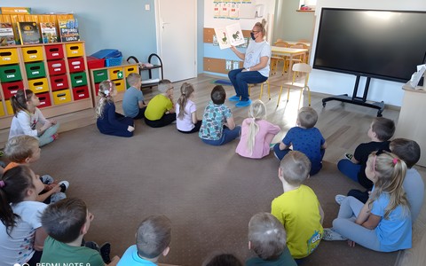 Pani Gosia czyta przedszkolakom książkę G.Van Genechten pt. Dziobem, piórem i pazurem o dinozaurach.