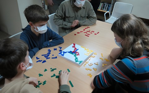 Rozgrywka finałowa! Remigiusz, Maksym, pan Mikołaj i Olga walczą o tytuł Mistrza Blokusa.