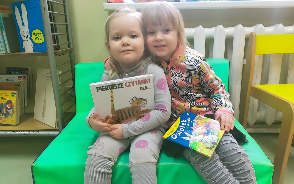 Antosia i jej starsza siostra trzymają książeczki