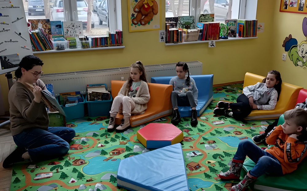Bibliotekarka czyta dzieciom książkę.