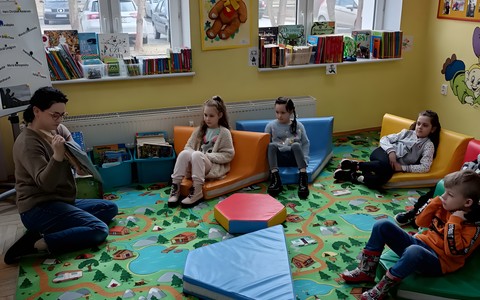 Bibliotekarka czyta dzieciom książkę.