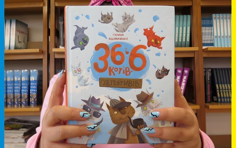 Zdjęcie przedstawia osobę trzymającą książkę dla dzieci w języku ukraińskim