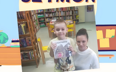 Chłopiec z bibliotekarką prezentują książeczkę