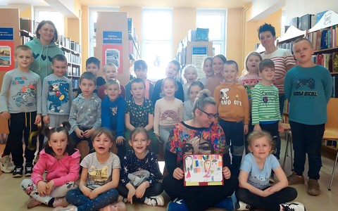 Grupa EKOTROPKÓW siedzi na podłodze i pozuje do pamiątkowego zdjęcia z Panią Gosią