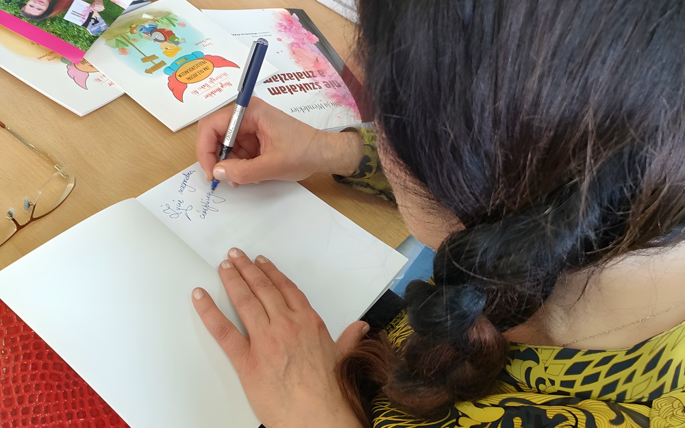 autorka składa dedykację w swojej książce