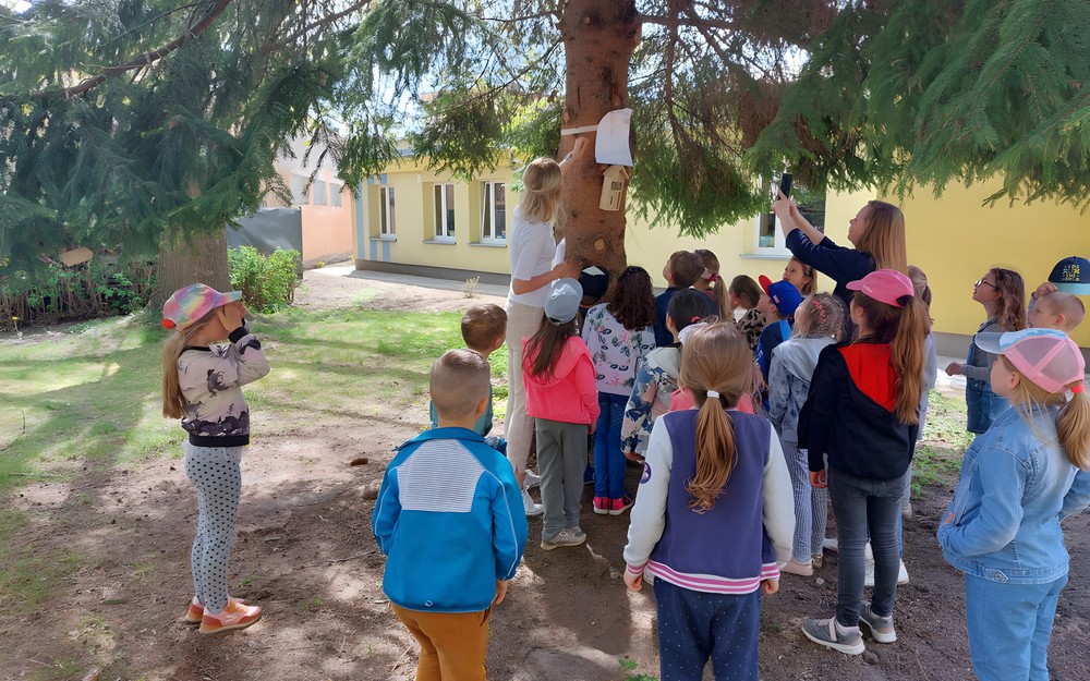 Dzieci stoją przy drzewie