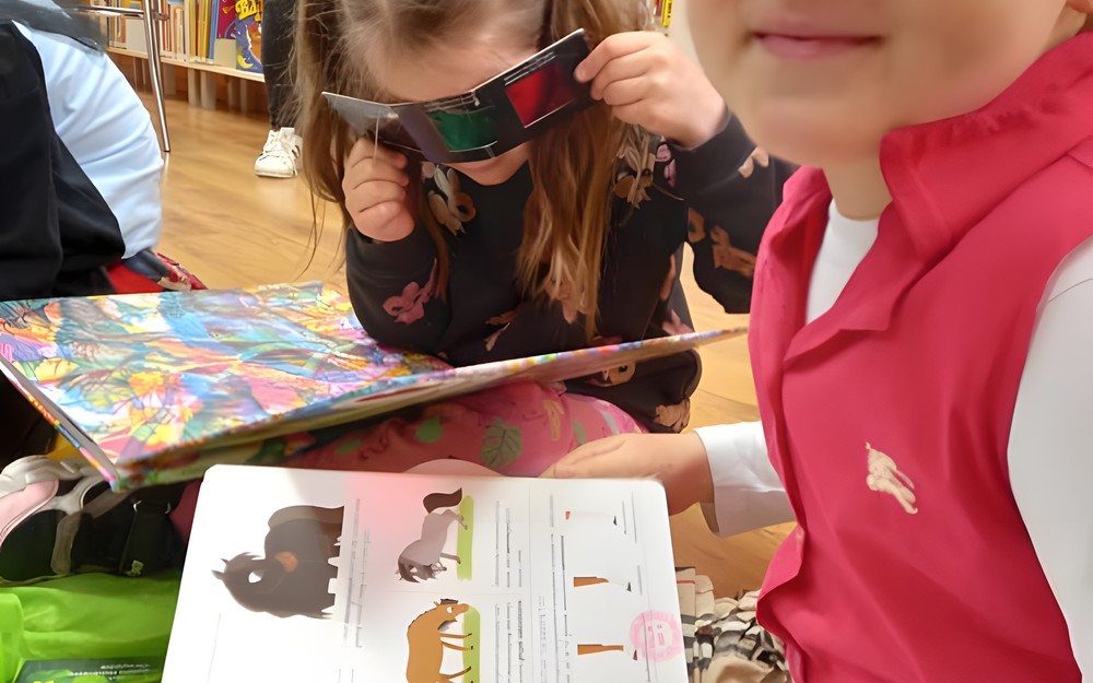 Na zdjęciu dziewczynka przeglądająca książkę