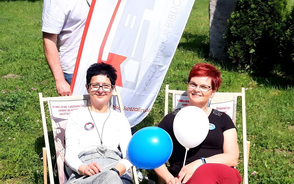 Zdjęcie przedstawia bibliotekarzy Piotra, Małgorzatę i Dorotę z ekwipunkiem festynowym