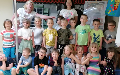 Zdjęcie grupowe: przedszkolaki wraz z bibliotekarką i wychowawcą stoją na scenie