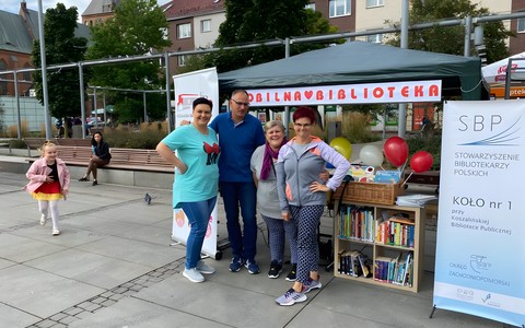 Bibliotekarska ekipa przy stoisku biblioteki