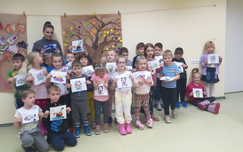 Dzieci z bibliotekarką prezentują swoje prace