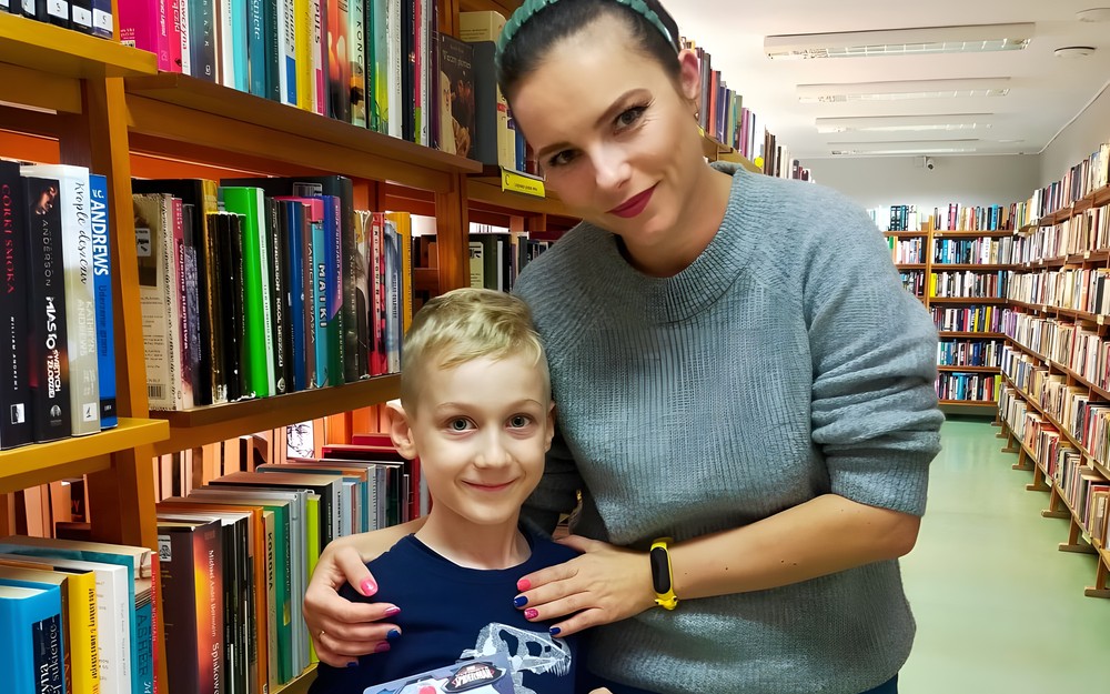 chłopiec z bibliotekarką pokazują dyplom