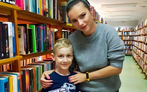 chłopiec z bibliotekarką pokazują dyplom