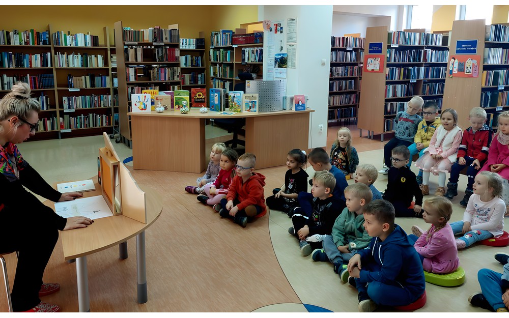 Gosia rozpoczyna zajęcia z przedszkolakami czytająć WĘDRÓWKĘ PĘDZLA I OŁÓWKA w teatrzyku kamishibai