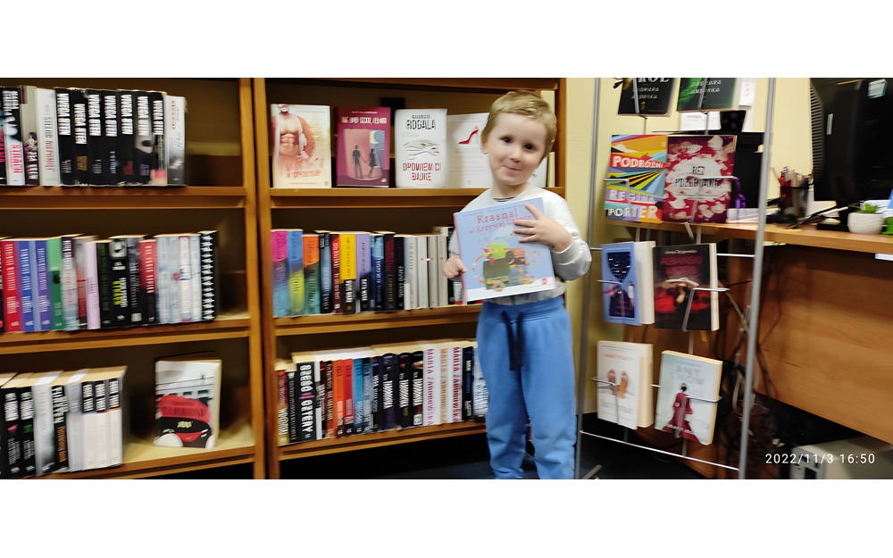 chłopiec pozuje do zdjęcia z pakietem Mała książka wielki człowiek