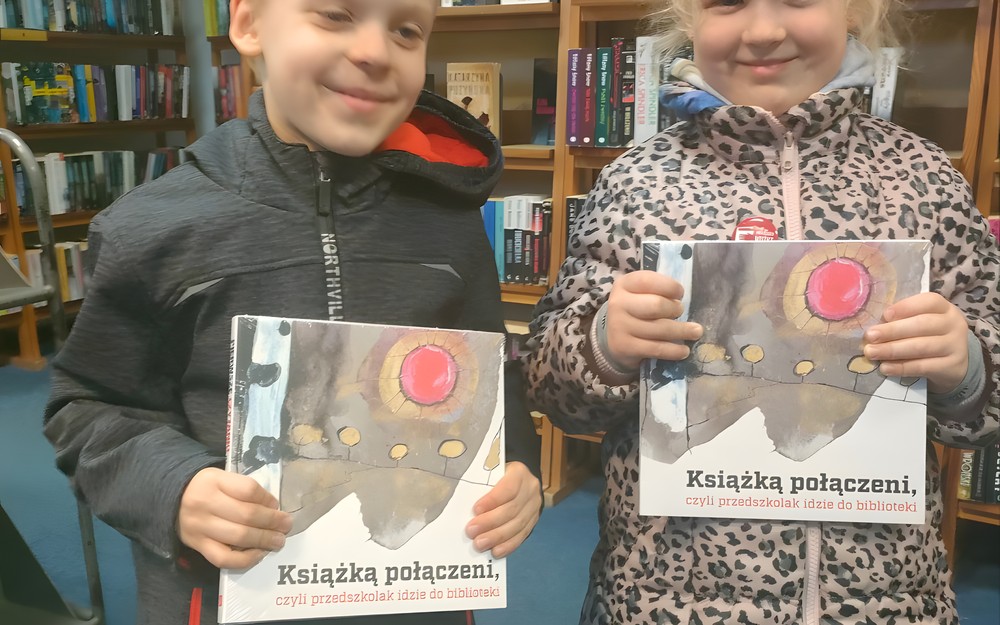 dzieci pozują do zdjęcia z pakietami mała książka, wielki człowiek