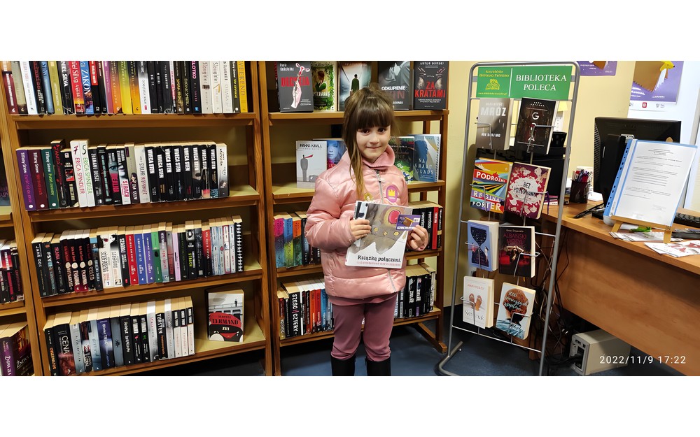 dziewczynka pozuje do zdjęcia z pakietem Mała książka, Wielki człowiek