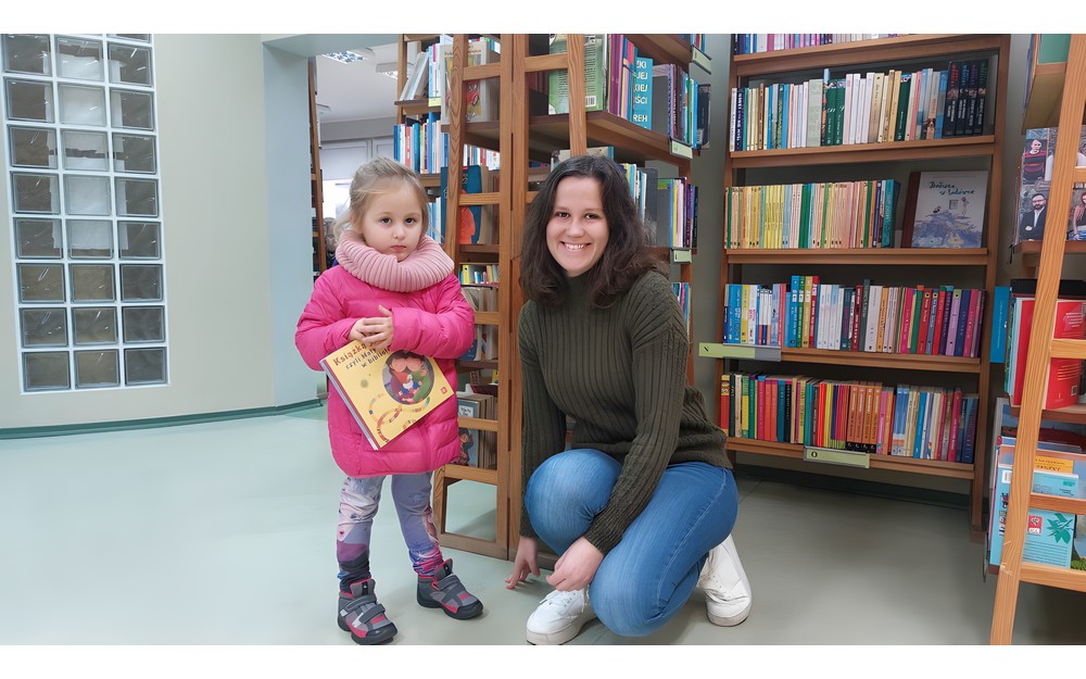 Dziewczynka z bibliotekarką prezentują książkę z akcji Mała książka - Wielki Człowiek