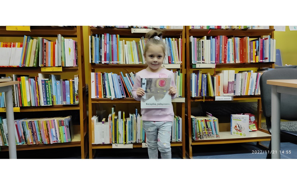 dziewczynka pozuje do zdjęcia z pakietem Mała książka, Wielki człowiek