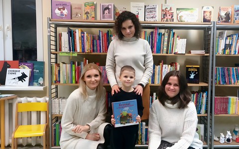 Jurek w towarzystwie trzech bibliotekarek pozuje do zdjęcia z książeczką