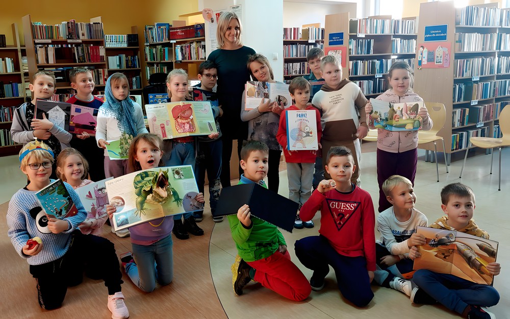 Dzieci z klasy IF wraz z wychowawczynią pozują do wspólnego zdjęcia w bibliotece