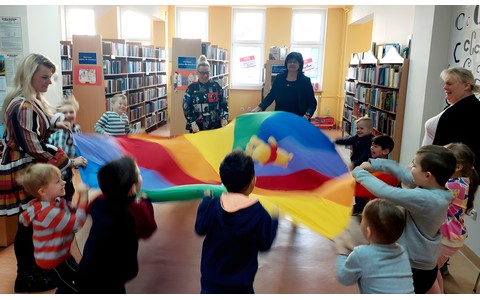 Przedszkolaki z grupy MOTYLKÓW usypiają pluszowego misia, kołysząc chustą animacyjną