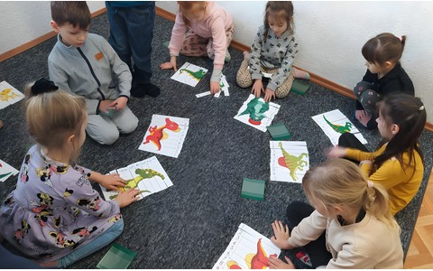Grupa Wisienki układa puzzle z wizerunkiem dinozaurów