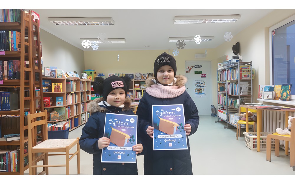 Dzieci pozują do zdjęcia z dyplomami