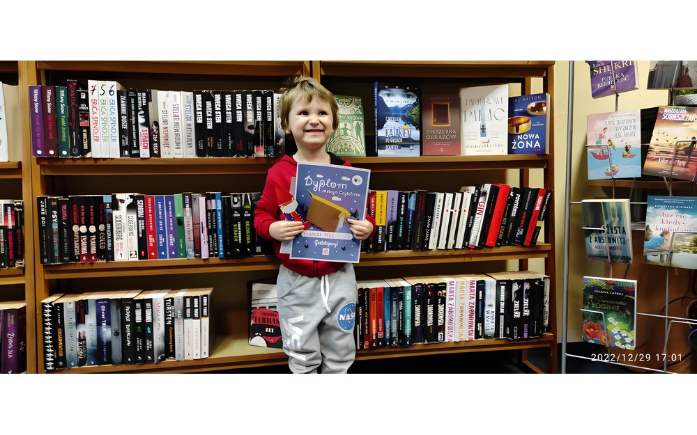 chłopiec pozuje do zdjęcia z dyplomem Mała książka wielki człowiek