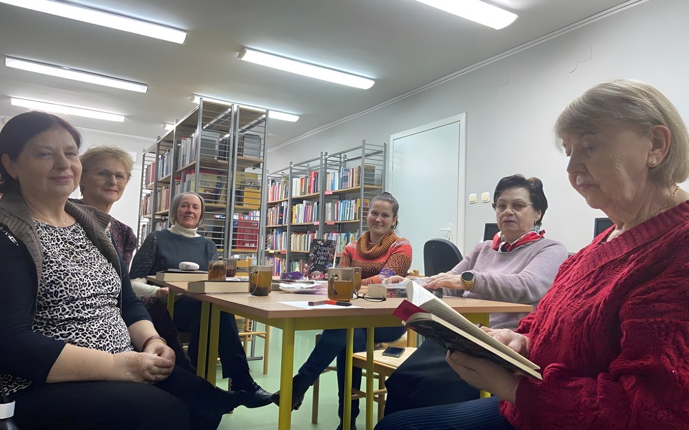 Klubowiczki siedzą przy stoliku i rozmawiają o książce Wszystkie kwiaty Alice Hart