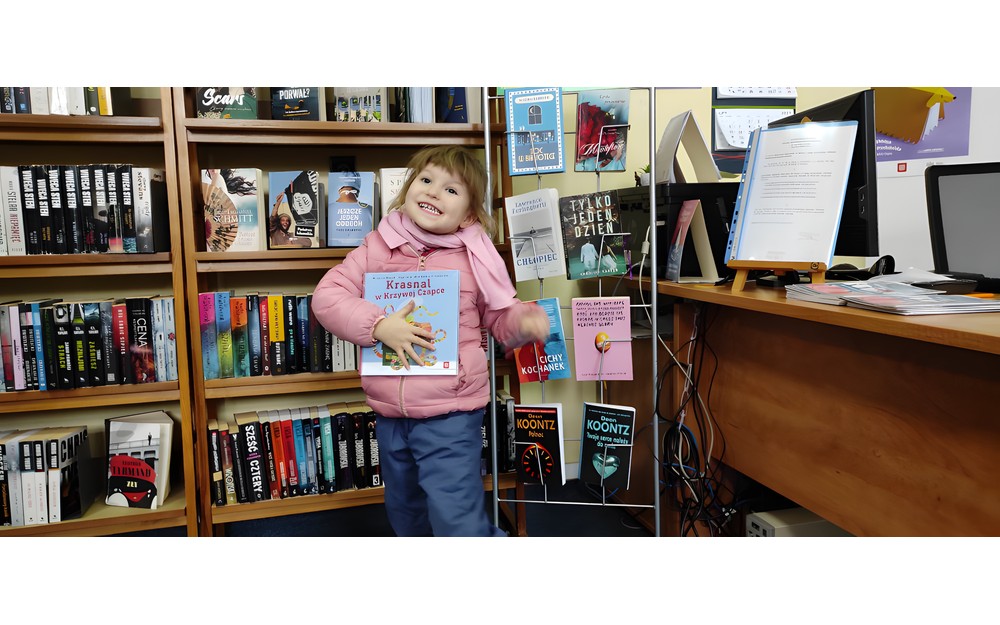 mała czytelniczka pozuje z pakietem do zdjęcia