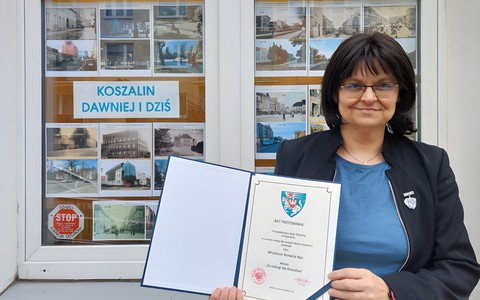 Na zdjęciu Wiola z aktem przyznania medalu ZA ZASŁUGI DLA KOSZALINA