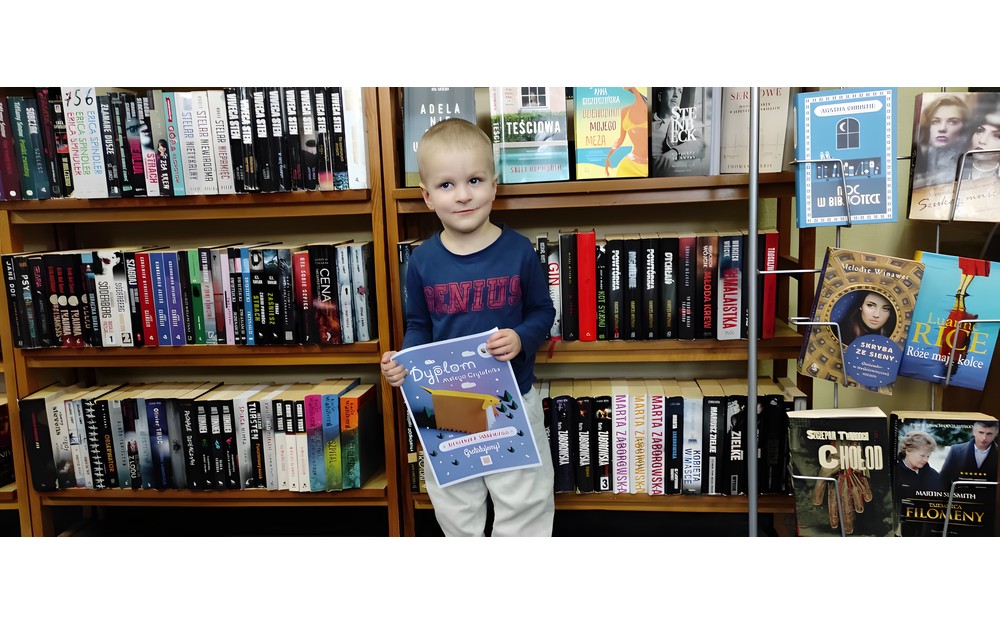 chłopiec pozuje z dyplomem "Mała książka, Wielki człowiek"