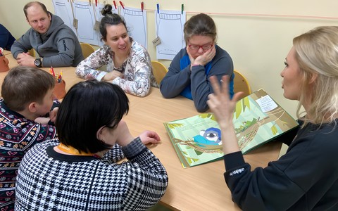 Bibliotekarka czyta uczestinkom zajęć książkę