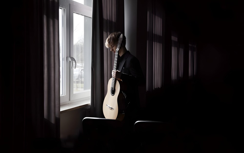 Zdjęcie przedstawia Jakuba Stańczyka z gitarą