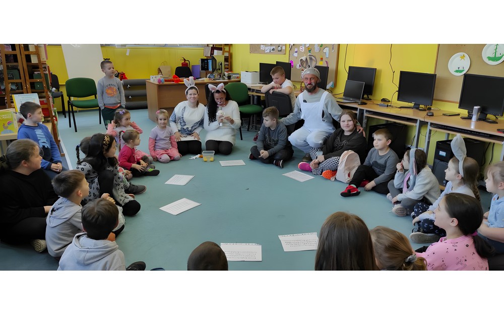 dzieci z prowadzącymi siedzą na podłodze i zgadują zagadki