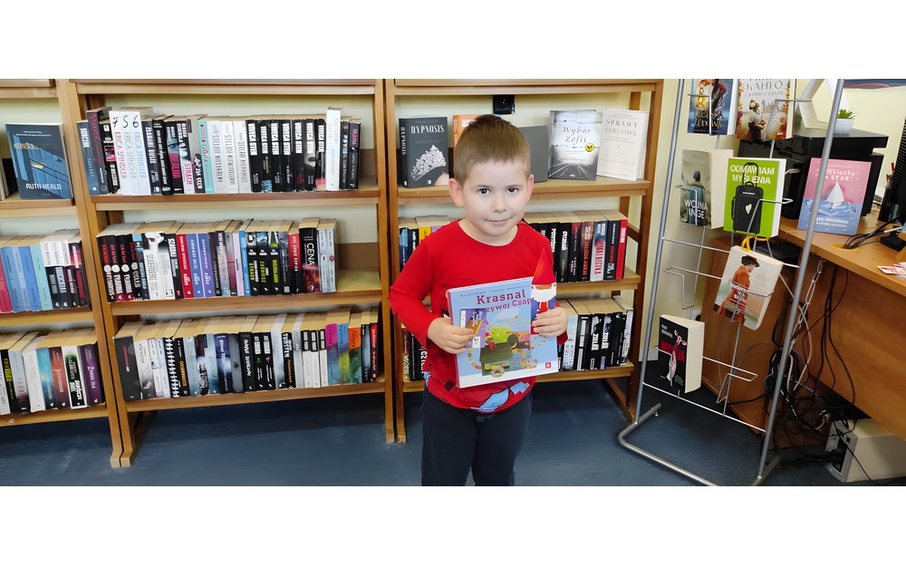 chłopiec pozuje z pakietem  "Mała książka, Wielki człowiek"