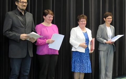 Jubilaci stoją na scenie w czasie Dnia Bibliotekarza w Koszalińskiej Bibliotece Publicznej