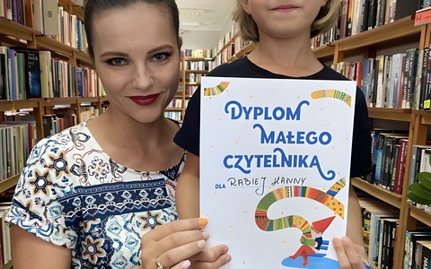 Dziewczynka z bibliotekarką prezentują dyolom