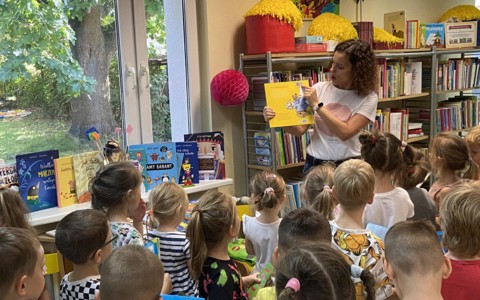 Bibliotekarka prezentuje dzieciom książkę