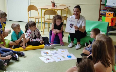 Bibliotekarka pokazuje plansze dzieciom