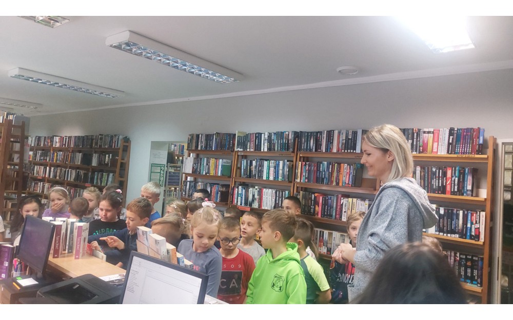 Bibliotekarka opowiada uczniom, jak zostać czytelnikiem