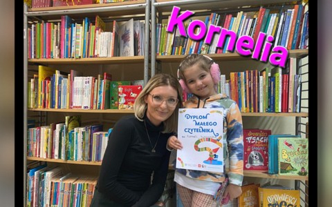 Dziewczynka pozuje z dyplomem i bibliotekarką