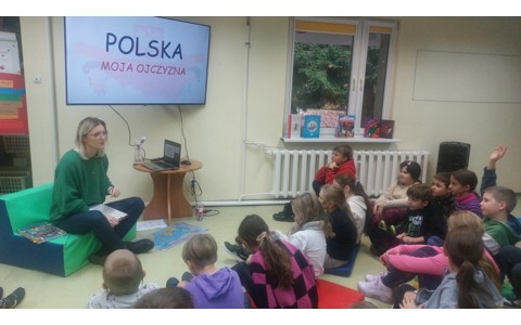 Uczniowie słuchają, bibliotekarki która opowiada o polskich symbolach narodowych
