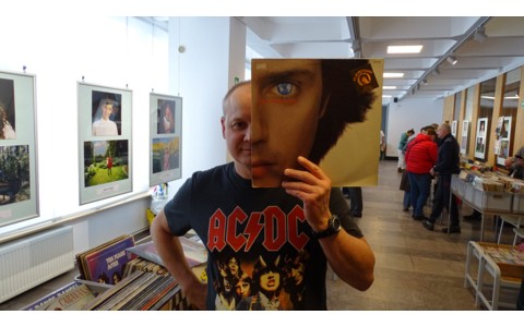 Uczestnik giełdy płytowej pokazuje płytę CD.